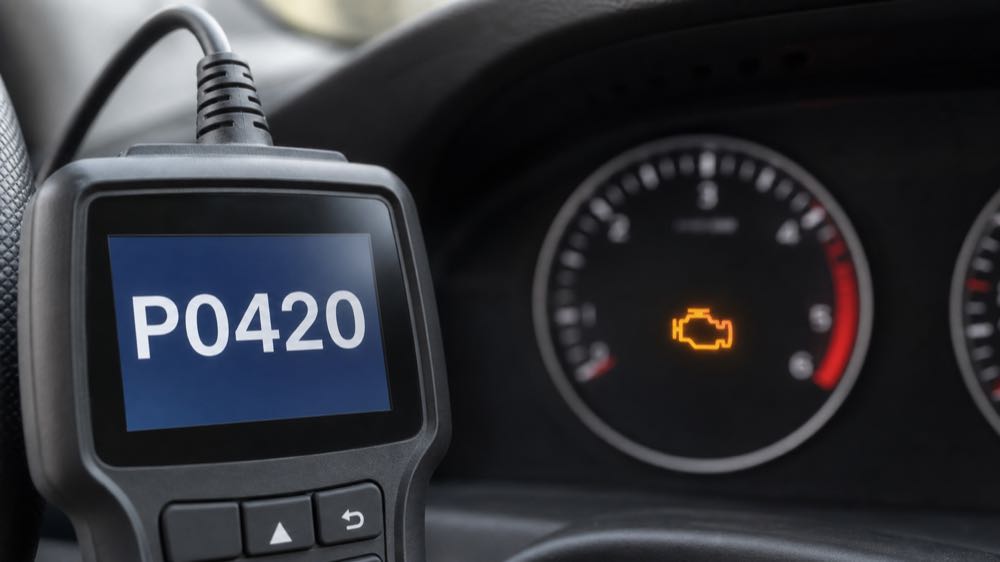 OBD2 scanner showing P0420 code with check engine light on