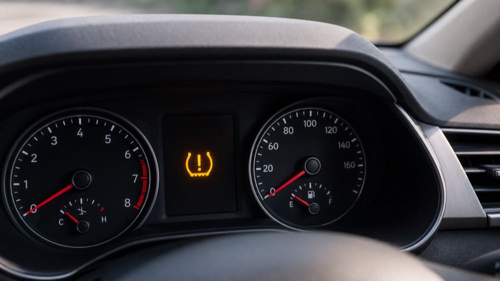 Amber tire pressure warning light illuminated on a modern car dashboard